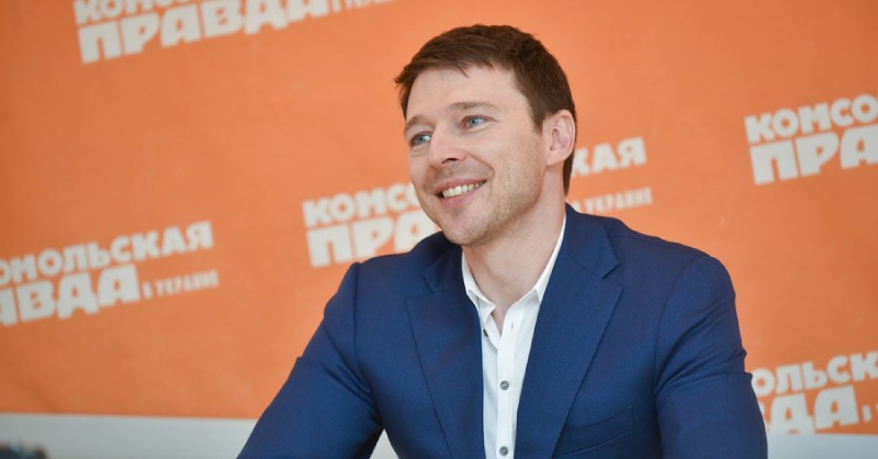 Володимир Локотко у синьому піджаку на тлі логотипу «Комсомольская правда в Украине» — інтерв’ю або публічний захід.