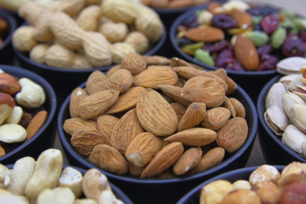 Мигдаль у синій мисці арахіс, фундук, кеш'ю, фісташки, ізюм